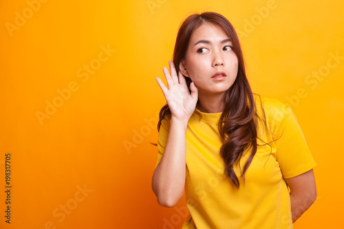 Beautiful young Asian woman listen to something.