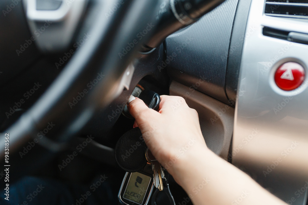 Women's hand turns the key to the car. Hands of the girl to take the keys to start the car engine. Key to start the car engine Women's hand turns the key to the car. Hands of the girl to take the keys to start the car engine. Key to start the car engine