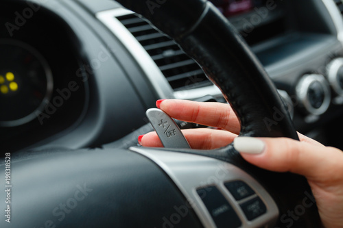 Wallpaper Mural Woman's hand switches the lobes of the gear selector on the steering wheel. Hand is switching car gear lever, close up shot of a manual gear changing paddle on a car's steering wheel. Torontodigital.ca