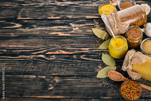 A set of mustard and spice. On a wooden background. Top view. Copy space for your text.