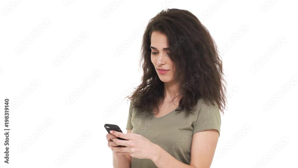 Portrait of happy caucasian woman 20s using smartphone scrolling feed news and finding good information, over white background. Concept of emotions Portrait of happy caucasian woman 20s using smartphone scrolling feed news and finding good information, over white background. Concept of emotions