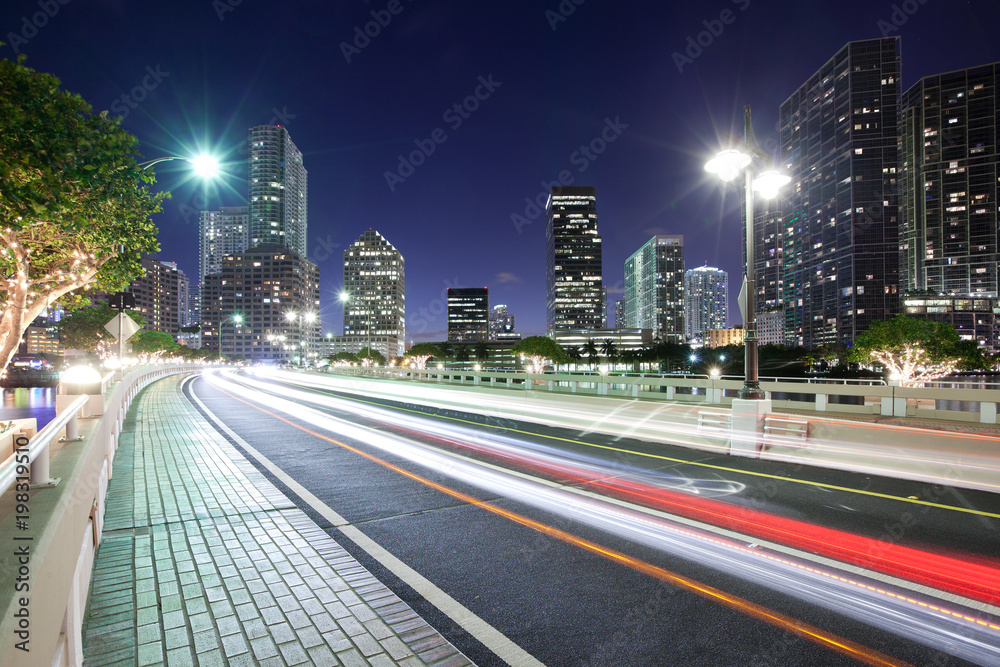 Streaking lights on Brickell key Drive with Brickell district skyline, Miami, Florida, USA