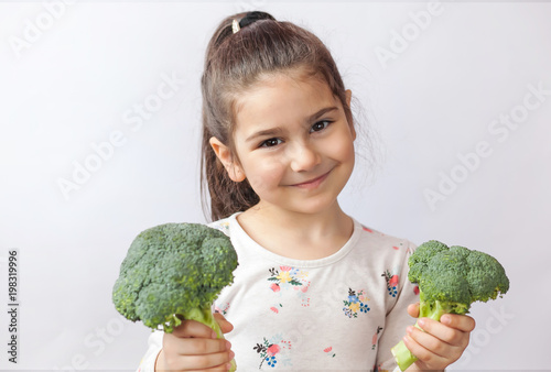 Happy smiling child girl with vegetables. Healthy food.