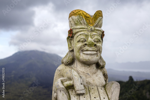 Traditional Balinese sculpture against the background of the volcano Batur. Island Bali  Indonesia