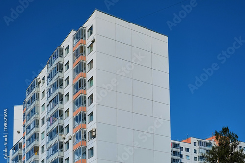 Modern concrete blocks apartment building with a deep blue sky background