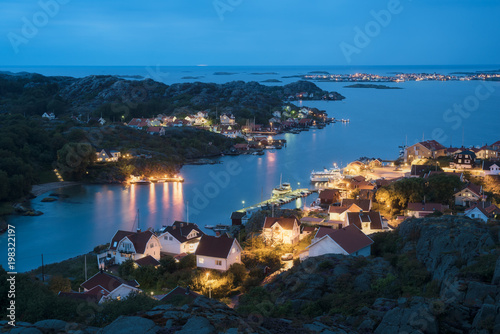 View at the harbor with a coastal city on an island during blue hour.