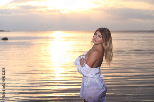 fashion photography with pretty woman in the water at sunset