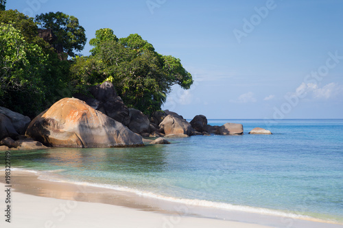 A beach on the Seychelles island with white sand and stones