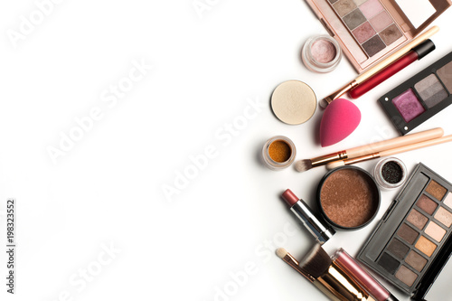 Flat lay of makeup palettes, eyeshadow pigments and lip gloss. Space for text
