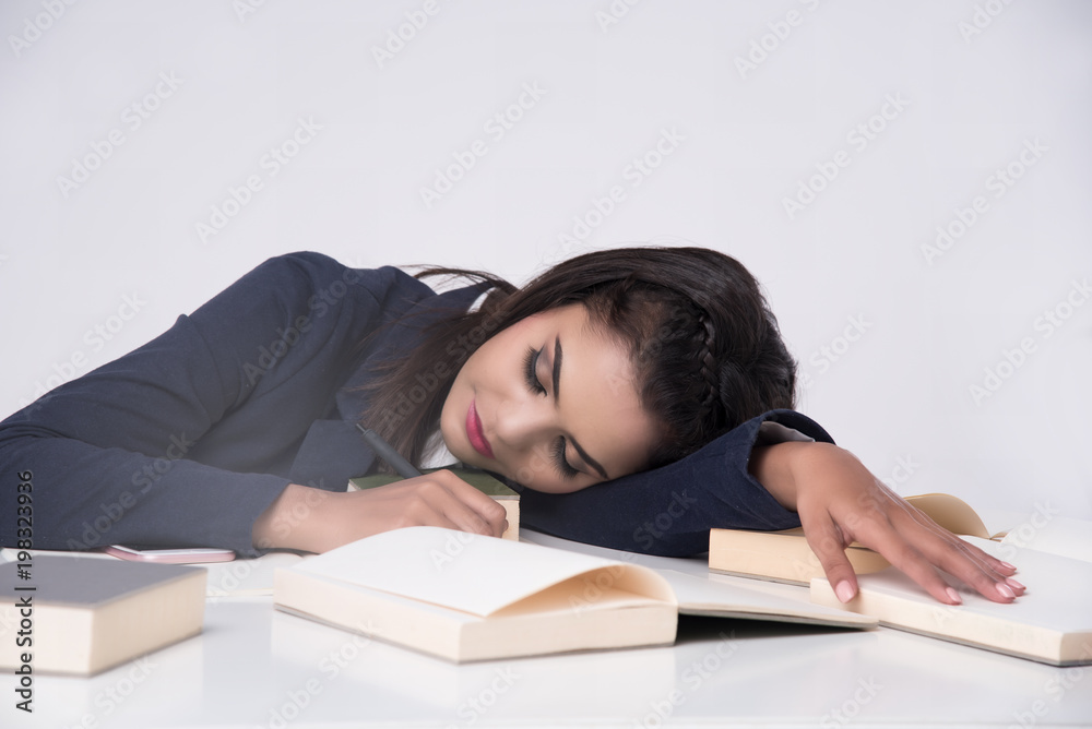 Beautiful office woman sit and sleep at table in office ,she work hard with laptop and use pen write report on notebook. She tried and want to relax. Beautiful office woman sit and sleep at table in office ,she work hard with laptop and use pen write report on notebook. She tried and want to relax.