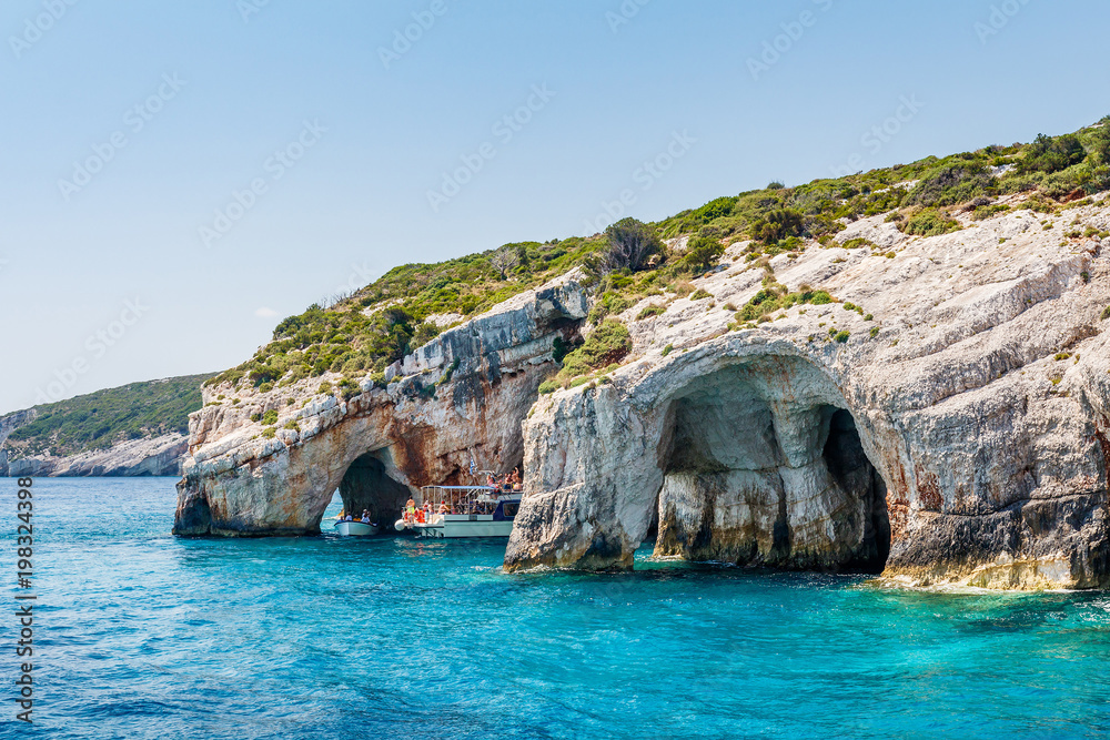 Tourist boats close to Blue caves at the cliff of Zakynthos island with, Greece