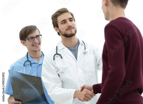 smiling doctor shaking hand of a patient
