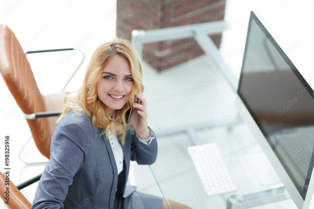 © ASDF - successful young business woman sitting at a Desk