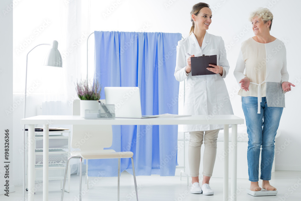 Fototapeta premium Happy woman standing on weight