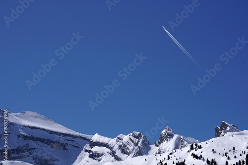 Airplane trails tracks chemtrails in the deep blue sky photo