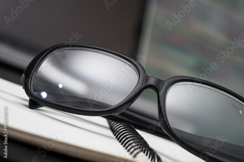 Black framed glasses on the computer keyboard with a very shallow depth of field. Copy space for text