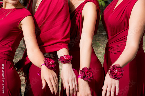 bride and bridesmaids with red bracelets on hands. Close up hands.