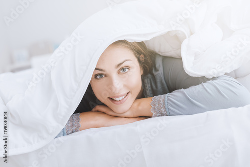 Woman hiding under covers