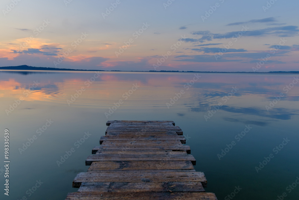 Pier on the mountain lake during sunset