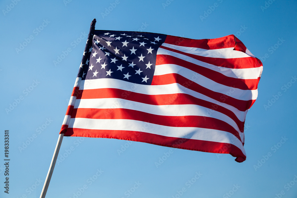 American flag waving on blue sky background