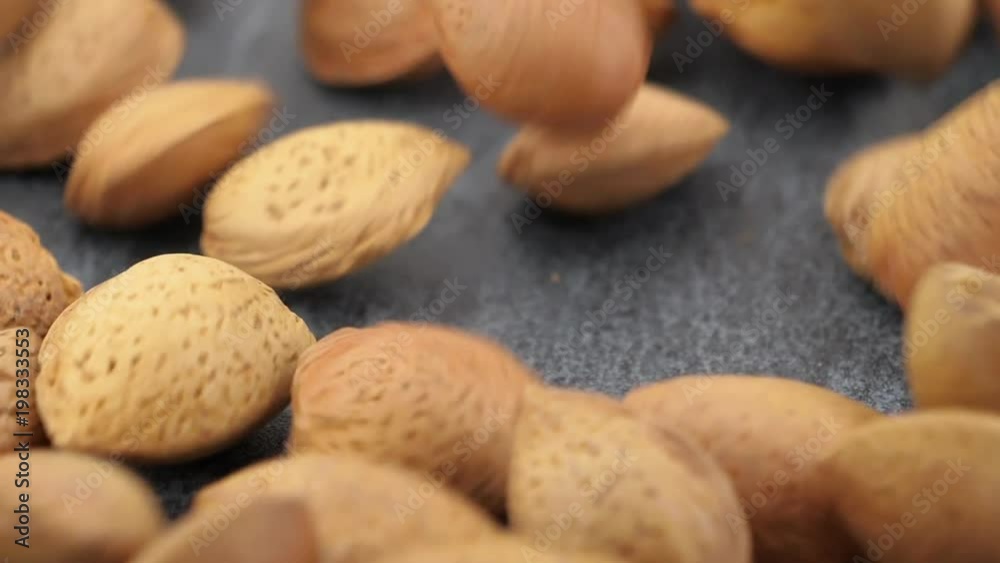 Almonds on gray stone background, slow motion, close-up Almonds on gray stone background, slow motion, close-up