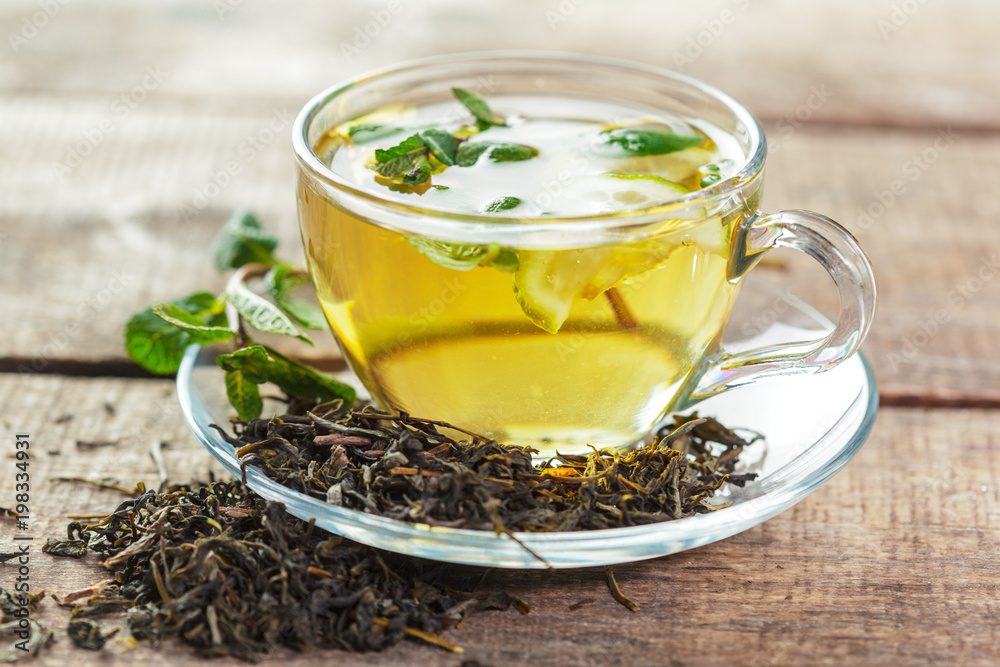cup of black tea with mint leaves on a wooden table cup of black tea with mint leaves on a wooden table