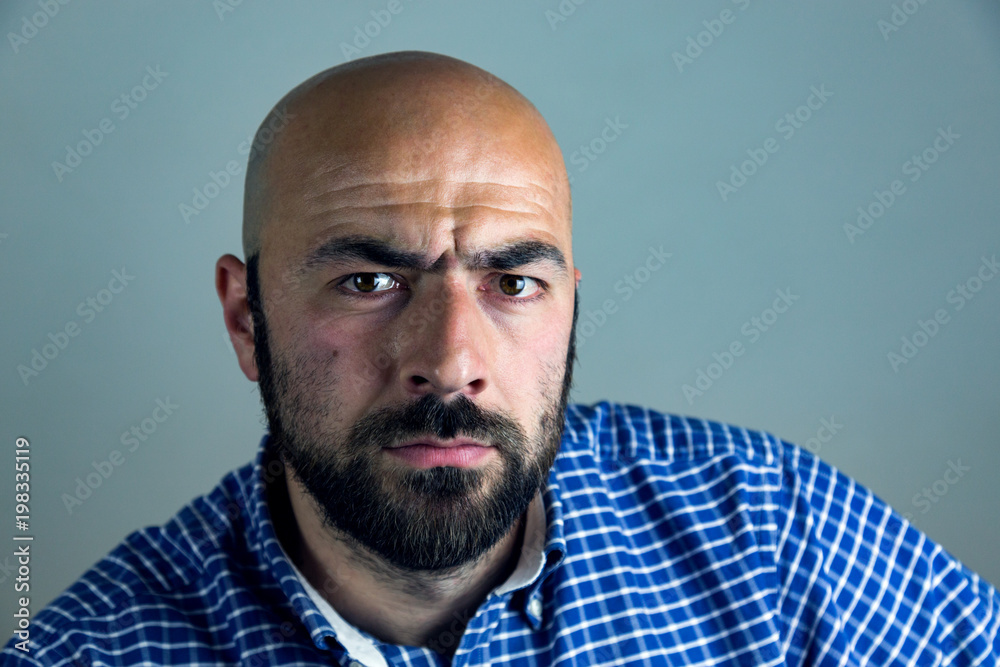 Portrait of bald man with beard in studio.Man showing different emotions. Portrait of bald man with beard in studio.Man showing different emotions.