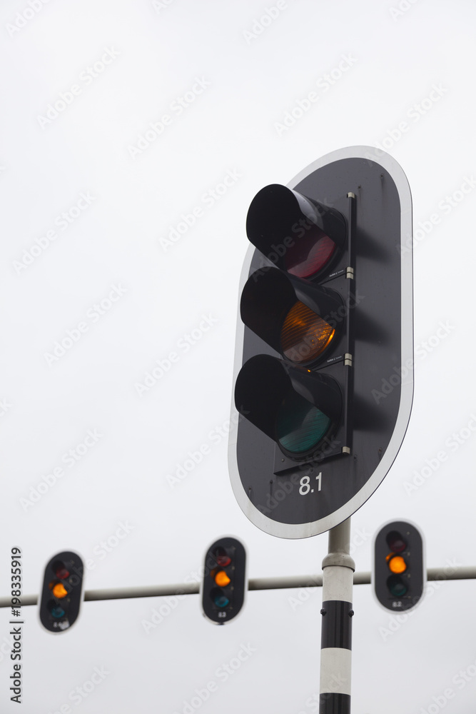 closeup of orange traffic lights and overcast sky closeup of orange traffic lights and overcast sky