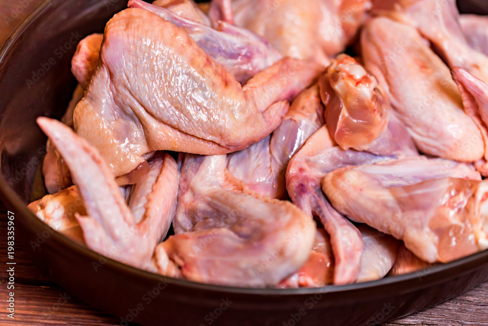 Fresh raw chickens wings in frying pan