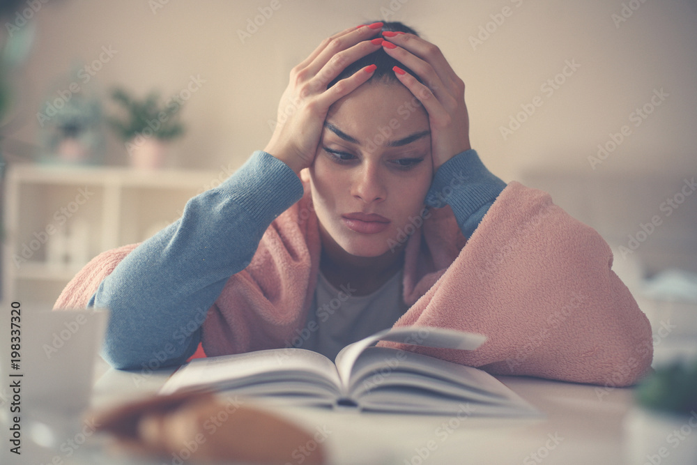 Young tired student girl sitting on floor and reading book. Young tired student girl sitting on floor and reading book.