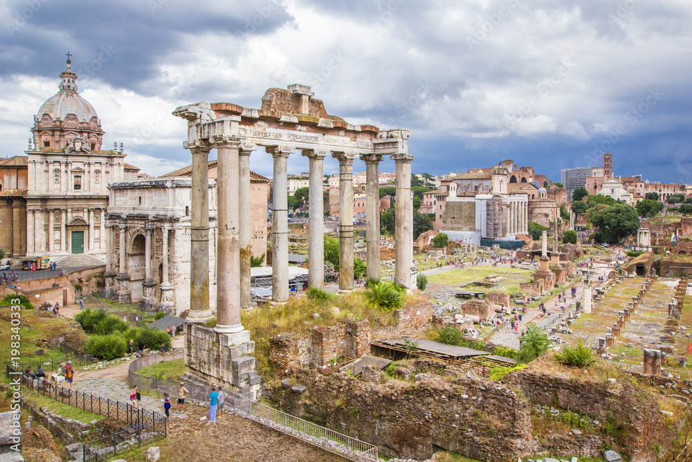 Panoramic view of Roman Forum with ancient ruins of temple, columns of Saturn, Triumphal Arch of Septimius Severus, Rome, Italy