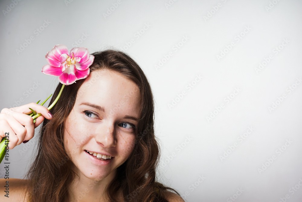 cute blue-eyed girl smiling, holding a fragrant pink flower cute blue-eyed girl smiling, holding a fragrant pink flower