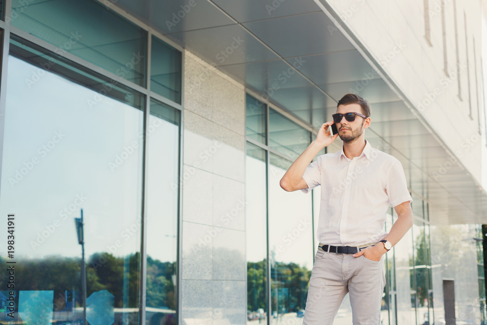 Young thoughtful businessman making a phone call outdoors Young thoughtful businessman making a phone call outdoors