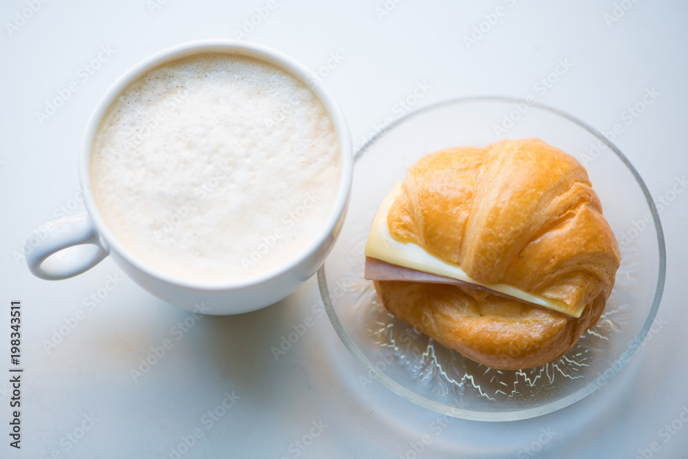 A cup of Black coffee with Ham and cheese croissant A cup of Black coffee with Ham and cheese croissant