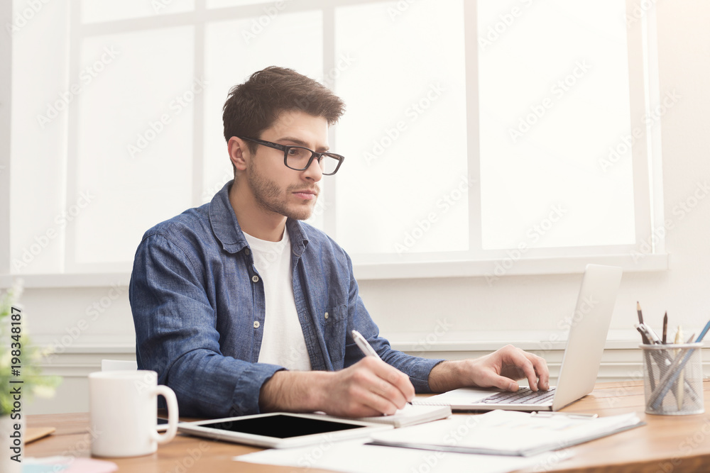 Young businessman working with laptop in office