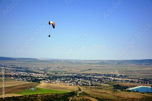Lonely paraglider soars high in the sky
