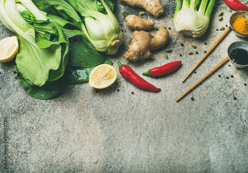 Asian cuisine ingredients over concrete background, top view, copy space. Flat-lay of vegetables, spices and sauces for cooking vietnamese, thai or chinese food. Clean eating, vegetarian concept