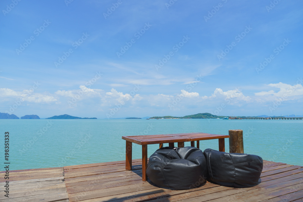 Wooden table and brown chairs with a beach front view - Perfect place to relax and have breakfast.