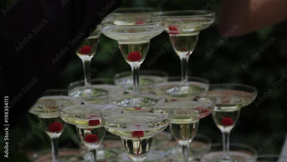 The guests' hands take glasses with bubbling wine at the party. Glasses are built in the pyramids. No recognizable persons. The guests' hands take glasses with bubbling wine at the party. Glasses are built in the pyramids. No recognizable persons.