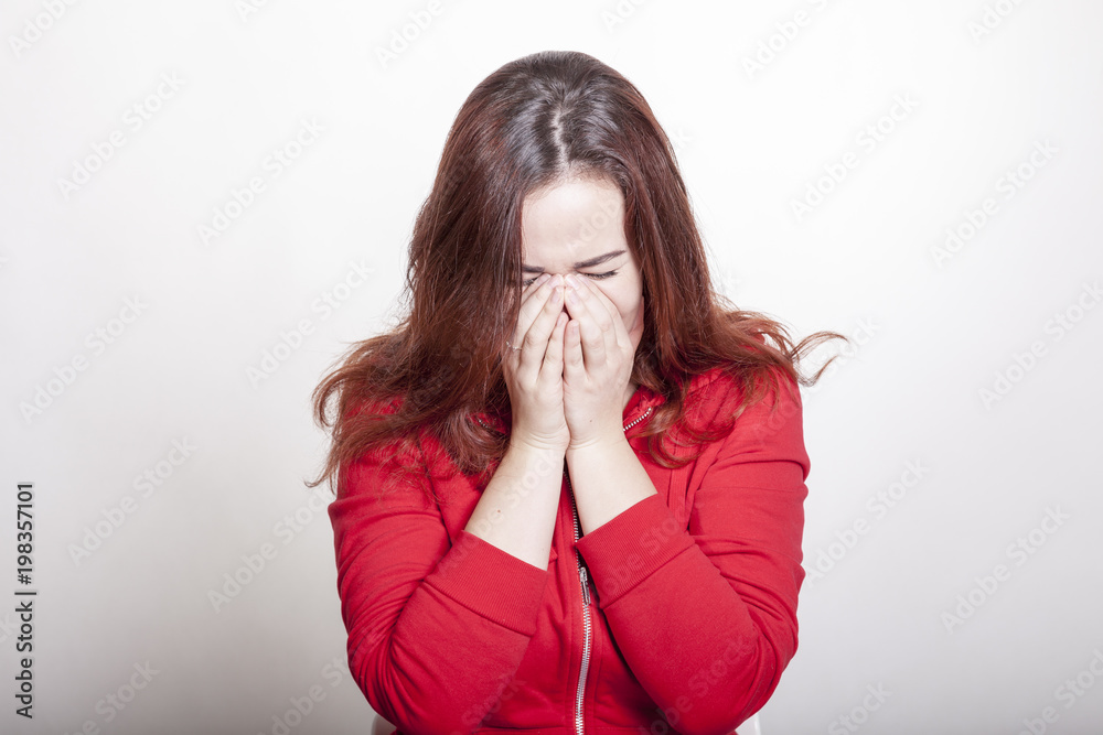 Depressive Frau hält ihre Hände vors Gesicht weil sie weinen muss