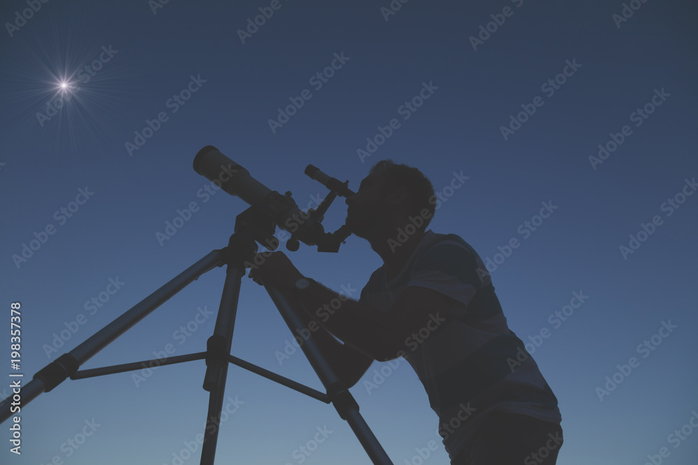 Man looking at the stars with a telescope.