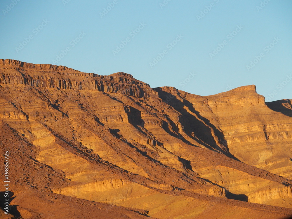 Rocky Atlas Mountains range landscape at sun set in southeastern Morocco near old village Oulad
