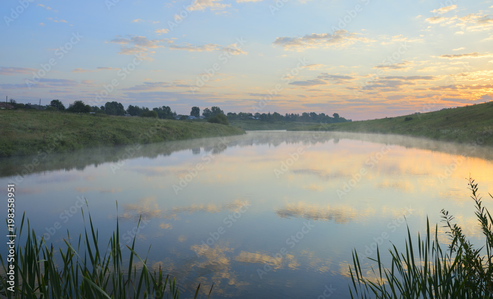 Foggy summer landscape.Rising sun.Serene morning.Calm.River Krasivaya Mecha in Tula region,Russia. 