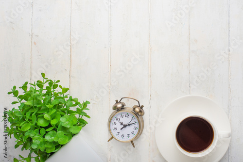 Alarm clock, coffee and flowers. Morning mood, on a white background, top view, with a blank space for an inscription or advertisement.