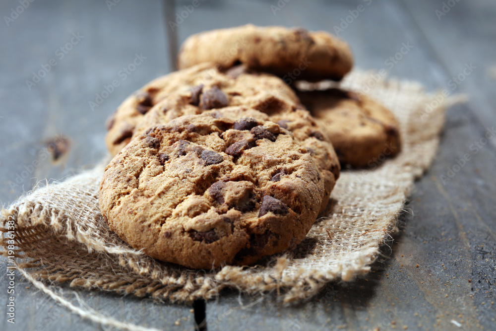 Fototapeta premium Chocolate cookies on wooden table. Chocolate chip cookies