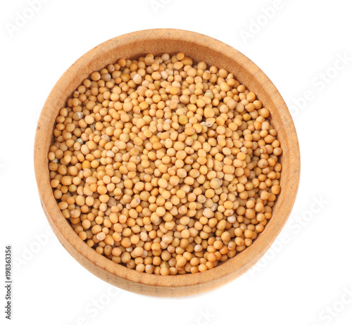 mustard seeds in wooden bowl isolated on white background. top view
