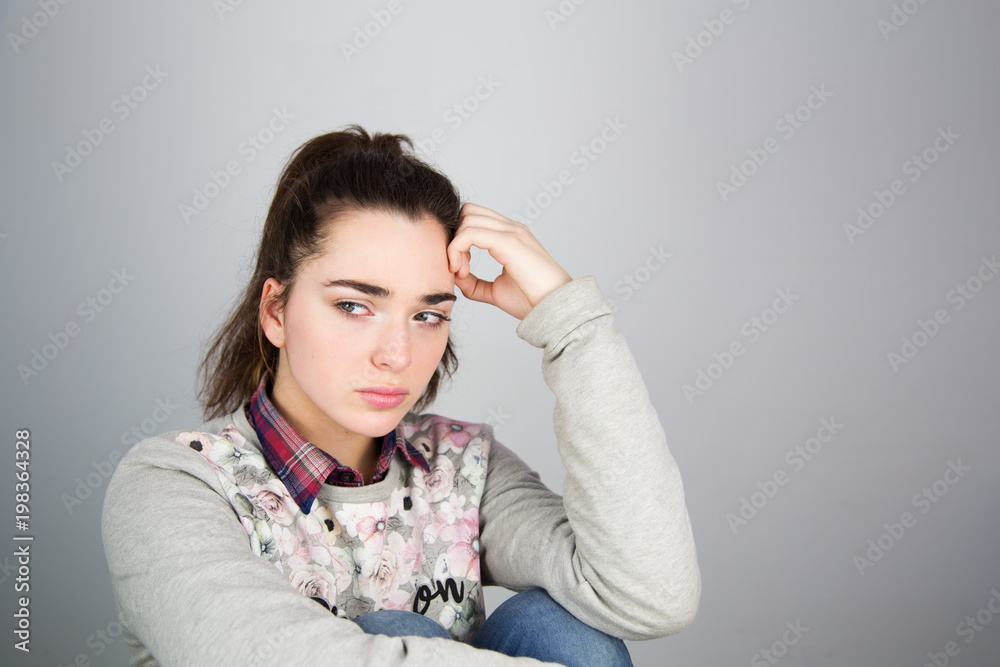 A portrait of a sad, hopeless, discouraged, joyless, melancholic, sorrowful, tired, frustrated, depressed beautiful young caucasian girl on a gray background with mock up copy space A portrait of a sad, hopeless, discouraged, joyless, melancholic, sorrowful, tired, frustrated, depressed beautiful young caucasian girl on a gray background with mock up copy space