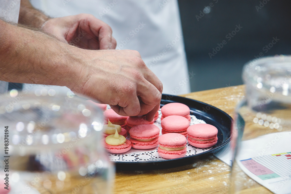 Фотография chef with macaroons on tray at bakery