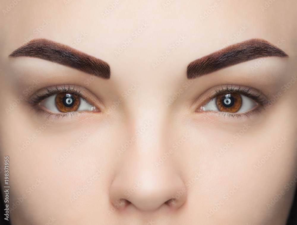 Naklejka premium Portrait of a woman with beautiful, well-groomed eyebrows, after dyeing a beauty salon. Professional eyebrow care, dyeing and permanent make-up.