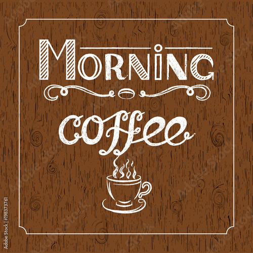 Hand drawn lettering  Morning coffee  with charcoal effect and view of a cup of coffee on brown wood background.